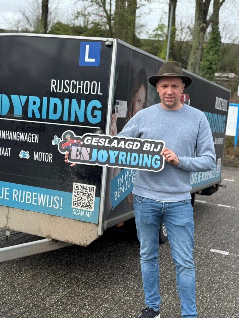 Geslaagde cursist toont certificaat bij Rijschool EnjoyRiding aanhangwagen trailer Geslaagde cursist toont certificaat bij Rijschool EnjoyRiding aanhangwagen trailer