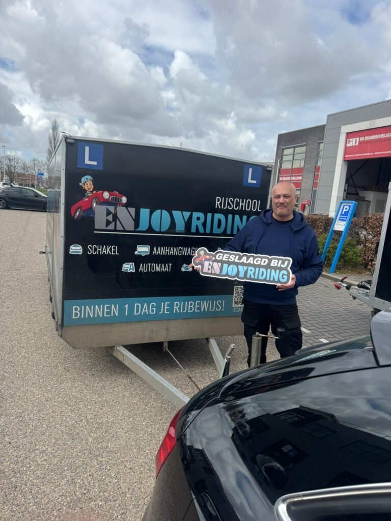 Geslaagde cursist van Rijschool EnjoyRiding poseert trots met certificaat bij lesauto en aanhangertrailer Geslaagde cursist van Rijschool EnjoyRiding poseert trots met certificaat bij lesauto en aanhangertrailer