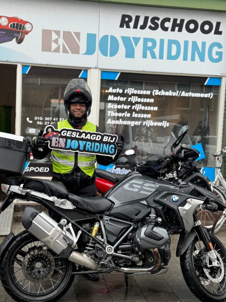 Geslaagde motorrijder met certificaat voor Rijschool EnjoyRiding naast BMW motor Geslaagde motorrijder met certificaat voor Rijschool EnjoyRiding naast BMW motor