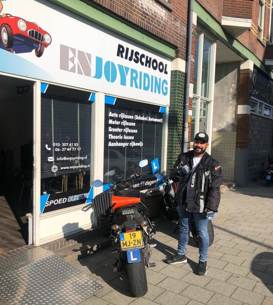 Geslaagde motorrijder met rijbewijs L voor rijschool EnjoyRiding winkel met motor Geslaagde motorrijder met rijbewijs L voor rijschool EnjoyRiding winkel met motor