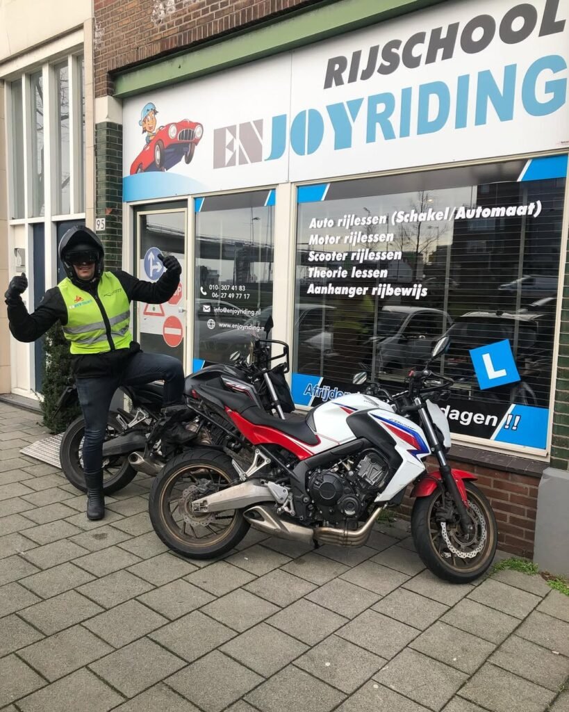 Geslaagde motorrijder viert motorrijbewijs bij Rijschool EnjoyRiding met Honda motor Geslaagde motorrijder viert motorrijbewijs bij Rijschool EnjoyRiding met Honda motor