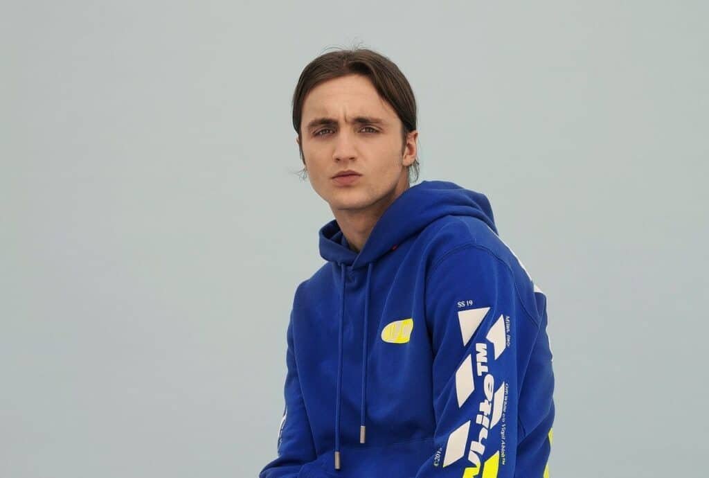 Kevin van rijschool EnjoyRiding draagt een blauwe hoodie tijdens een portretfoto